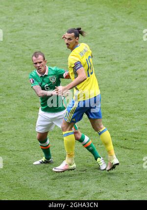 L'uomo Glenn Whelan della Repubblica d'Irlanda segna lo Zlatan Ibrahimovic svedese durante la partita del Campionato europeo UEFA 2016 allo Stade De France di Parigi. Foto data 13 Giugno 2016 Pic David Klein/Sportimage Foto Stock