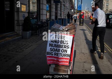 Londra, Regno Unito. 6 settembre 2021. Un uomo su Piccadilly passa un cartello per il quotidiano gratuito serale standard che mostra che oggi è il ritorno al lavoro per molti e i bambini sono tornati a scuola dopo le vacanze estive. I datori di lavoro hanno voluto che il personale tornasse nei loro uffici anche se la pandemia è in corso, ma molti hanno considerato il lavoro ibrido come un nuovo modello in avanti. Credit: Stephen Chung / Alamy Live News Foto Stock