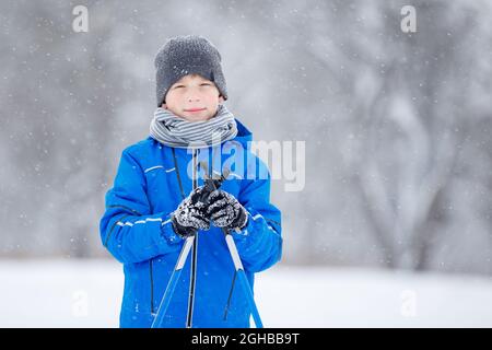 Primo piano ritratto di piccolo ragazzo sci nel parco invernale. Foto Stock