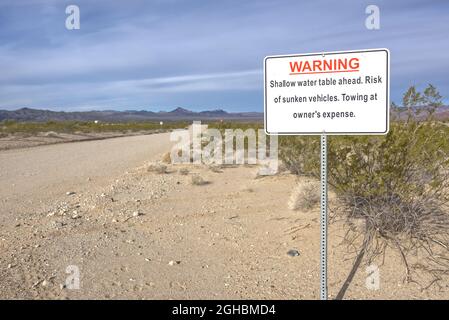 Strada di sabbia sinking. Un cartello segnaletico su una strada che porta ad Alamo Lake Arizona, avvertendo che il veicolo potrebbe affondare a causa della tavola d'acqua Foto Stock