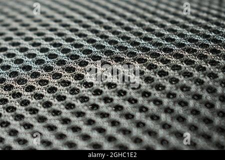 Primo piano di uno zaino grigio in poliestere con molti piccoli fori Foto Stock