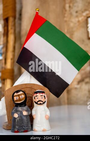 Decorazione della bandiera nazionale degli Emirati Arabi Uniti con figurine che indossano abiti tradizionali, Dubai, Giornata Nazionale degli Emirati Arabi Uniti. Foto Stock