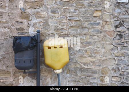 dettaglio di un rifiuti organici rifiuti può accanto a una batteria rifiuti rifiuti può in una città Foto Stock