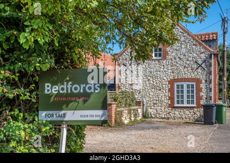 Per la vendita segno su una proprietà a Thornham sulla strada A149 lungo la costa nord del Norfolk. Foto Stock