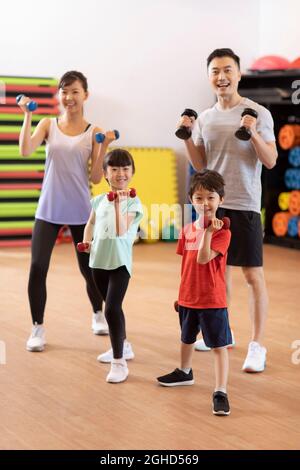 Felice famiglia giovane esercizio in palestra Foto Stock