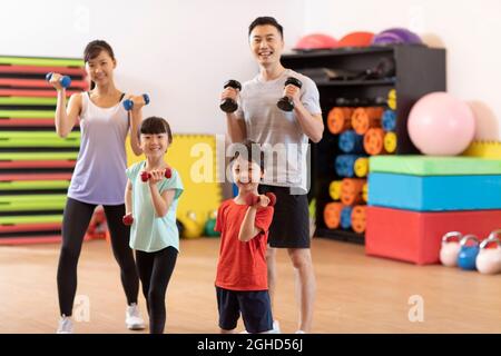 Felice famiglia giovane esercizio in palestra Foto Stock