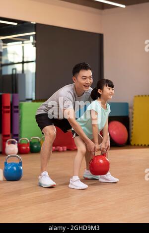 Bambina che ha lezioni di esercizio in palestra Foto Stock