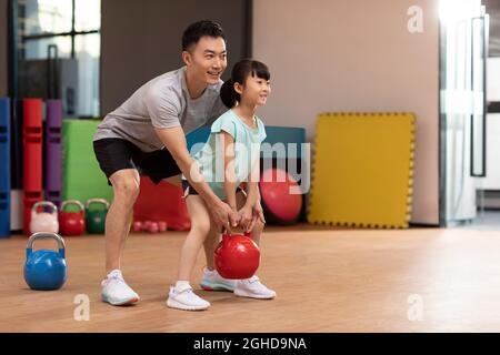 Bambina che ha lezioni di esercizio in palestra Foto Stock