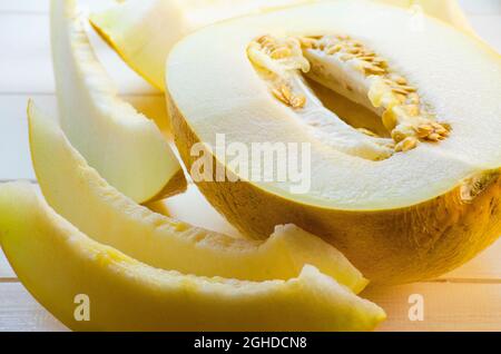 metà e fette di melone maturo su sfondo bianco Foto Stock