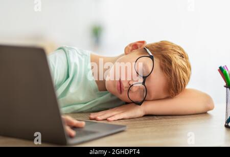 Il bambino stanco si addormentò mentre stava facendo i compiti Foto Stock