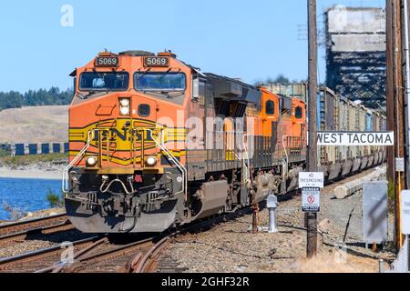 Un treno per rifiuti urbani BNSF da Tacoma dopo aver attraversato Chamber Creek sul ponte 14, dirigiti a sud verso una discarica vicino a Roosevelt, Washington Foto Stock