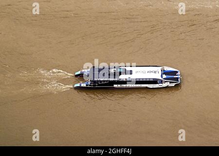 Londra, Inghilterra - Agosto 2021: Vista aerea di un taxi d'acqua Thames Clippers sul Tamigi. Il traghetto è sponsorizzato da Uber. Foto Stock