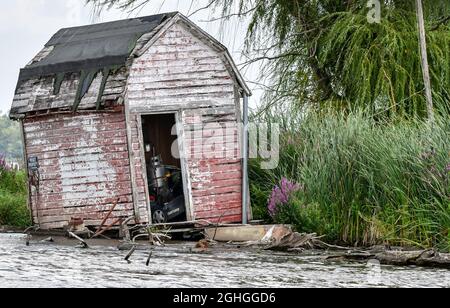 Rifugio da pesca abbandonato lungo l'acqua Foto Stock