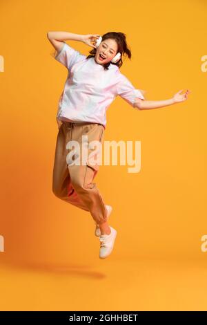 Ragazza allegra che ascolta musica Foto Stock