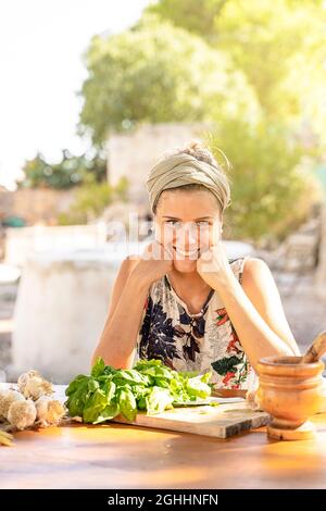 foto verticale di bella donna bruna felice di cucinare all'aperto Foto Stock
