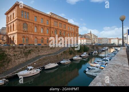 Vecchio edificio presso gli Scalo Olandesi, a Livorno. Barche ormeggiate lungo il Fosso reale. Foto Stock