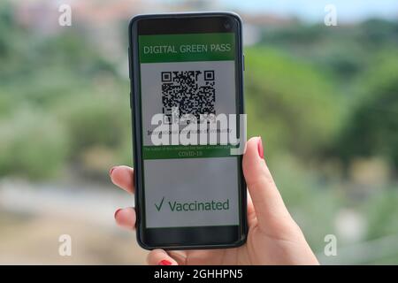 Donna tenere covid19 vaccino qr codice certificato verde pass su uno smartphone,TECH Foto Stock