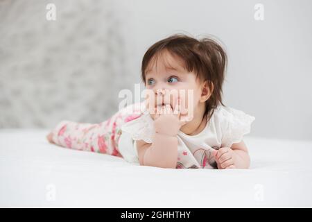 Felice bambino di sei mesi ragazza distesa su una coperta a casa Foto Stock