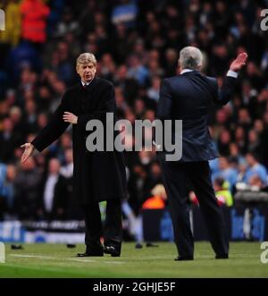 Il manager dell'Arsenal Arsene Wenger sostiene Mark Hughes con il manager della città di Manchester durante la partita della Carling Cup tra Manchester City e l'Arsenal presso lo stadio della città di Manchester. Foto Stock