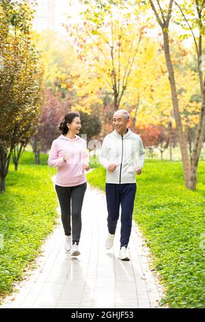 Felice coppia senior che corre nel parco Foto Stock