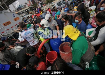 San Juan De Lurigancho, Perù. 06 settembre 2021. I residenti si accodano per un secchio di acqua potabile dopo che l'approvvigionamento è stato interrotto a causa di un tubo di scoppio. La società responsabile, Sedapal, ha affermato che la fornitura sarebbe stata "gradualmente ripristinata nei prossimi 7 giorni”. Credit: Gian Masko/dpa/Alamy Live News Foto Stock