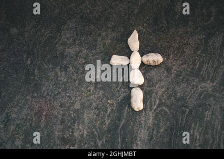 Piccola croce in pietra bianca su una lapide Foto Stock