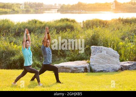 Coppia matura felice che fa yoga nel parco Foto Stock