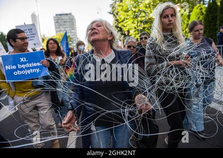 Varsavia, Polonia. 06 settembre 2021. Gli attivisti legati con un filo per simboleggiare la recinzione di filo spinato al confine con la Bielorussia sono visti bloccare la strada.il Parlamento polacco oggi sera ha formalmente approvato lo stato di emergenza in due regioni confinanti con la Bielorussia - il primo ordine del suo genere dai giorni comunisti polacchi. Molti dei principali partiti di opposizione polacchi hanno criticato lo stato di emergenza, sostenendo che si tratta di una reazione eccessiva che frena le libertà civili. (Foto di Attila Husejnow/SOPA Images/Sipa USA) Credit: Sipa USA/Alamy Live News Foto Stock