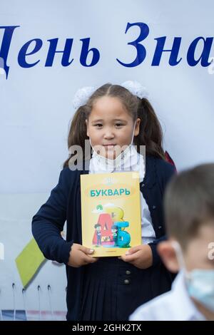 Bella ragazza in maschera andando a 1 grado a scuola Foto Stock