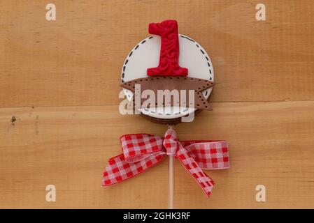 Lollipops al cioccolato decorato per il compleanno dei bambini in campagna, tema fattoria. Lolllipops sul tavolo di legno chiaro di pino. 1 anno a tema. Foto Stock