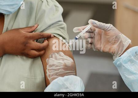 Immagine close-up della paziente di sesso femminile che riceve l'iniezione di vaccino contro il covid-19 in clinica Foto Stock