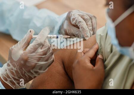 Immagine ravvicinata di una donna afroamericana vaccinata in clinica medica durante la pandemia di coronavirus Foto Stock