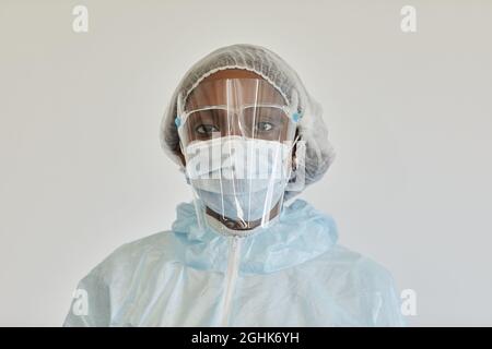 Ritratto di triste grave infermiere medico in PPE vestito guardando la macchina fotografica, è stanca dopo giorno di lavoro Foto Stock