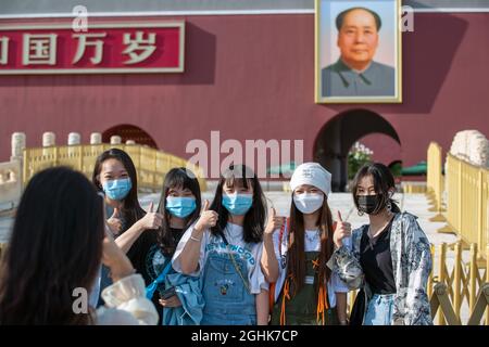 I turisti cinesi che indossano maschere scattano una foto di gruppo davanti alla porta Tiananmen con un ritratto di Mao Zedong. 07 settembre 2021 Foto Stock