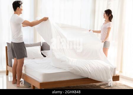 Felice famiglia giovane che dorme a letto Foto Stock