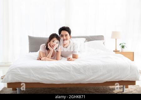 Felice coppia giovane sdraiato sul letto Foto Stock