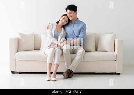 Allegro coppia giovane seduto sul divano Foto Stock