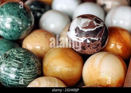 Sfondo full frame di collezione di palle di marmo multicolore assortite per arredamento in contenitore di legno Foto Stock