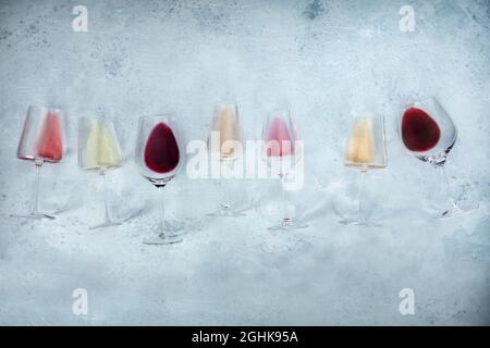Fondo del vino con bicchieri di vino rosa, rosso e bianco, girato dall'alto con spazio copia. Vari colori Foto Stock
