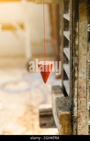 pendolo con prugna per trovare linea verticale Foto Stock