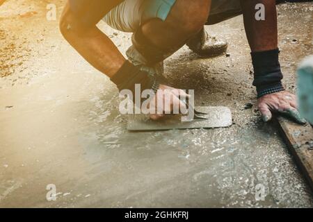 Mason costruzione di un rivestimento di rasatore cemento a casa Foto Stock