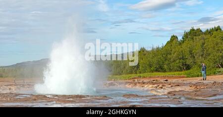 Geysir, Islanda - 28 luglio 2021: Geyser Strokkur in islanda errupting con acqua calda e vapore, ogni anno molti turisti visitano il geyser situato in Th Foto Stock