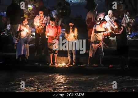 Kathmandu, Nepal. 07 settembre 2021. I devoti indù tengono la lampada ad olio mentre eseguono rituali religiosi sulle rive del fiume Bagmati durante la celebrazione del Kuse Aunse (Father's Day). Gli Indù di tutto il paese, i cui padri sono passati, vengono al tempio per adorare, fare delle sacre salse e presentare offerte in questa occasione. Credit: SOPA Images Limited/Alamy Live News Foto Stock