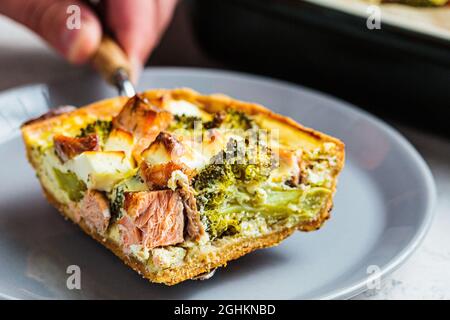 Pezzo di quiche torta con salmone e broccoli in piatto, primo piano. Foto Stock
