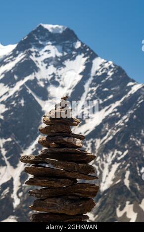 Equilibrio di pietre. Pietre equilibranti sulla parte superiore del masso. Primo piano. Equilibrio di pietre su un cielo blu e sfondo di montagne con uno spazio copia. Pietra Foto Stock