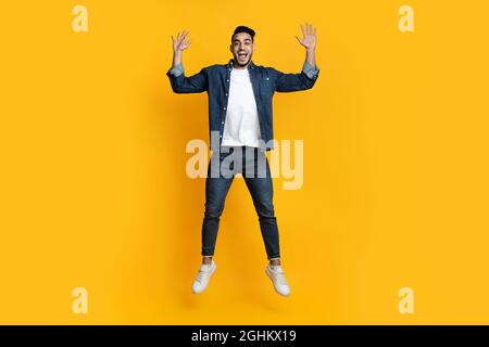 L'allegro uomo arabo salta, alzando le mani Foto Stock