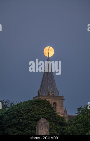 Luna piena che sorge dietro la guglia della cattedrale di Rochester Kent Foto Stock