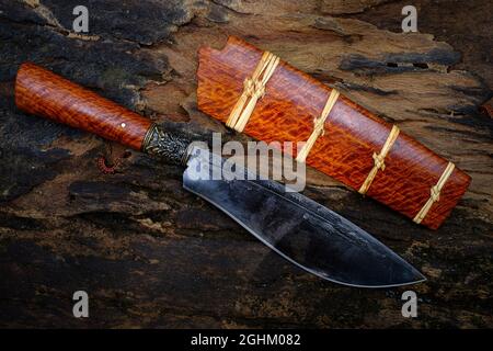 Coltello personalizzato o Enep nel legno naturale scabbard su vecchio sfondo tavolo fatto a mano di Thailandia Foto Stock