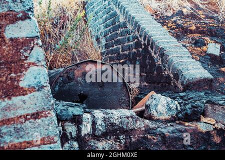 Bidón de metal deteriorado, en balsa de alquitrán y terreno contaminado Foto Stock