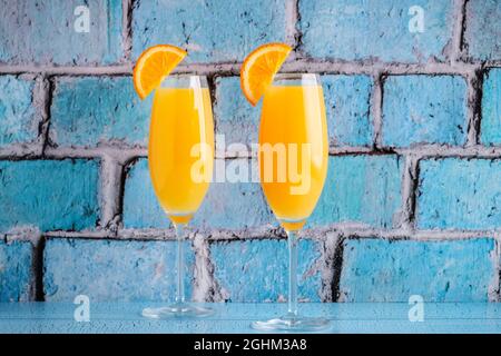 Rinfrescanti cocktail Mimosa all'arancia con champagne su sfondo luminoso. Foto Stock